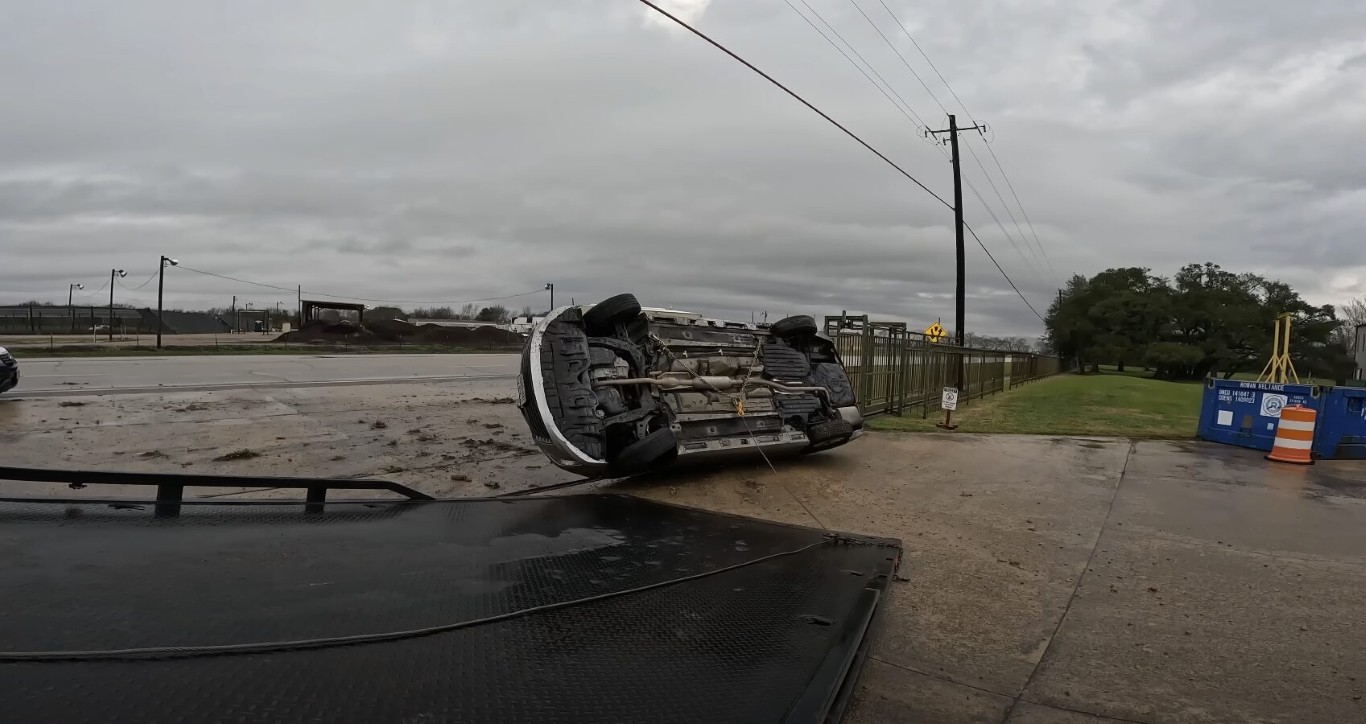 Emergency towing of a rolled-over vehicle on a rainy road in Bay Shore, NY