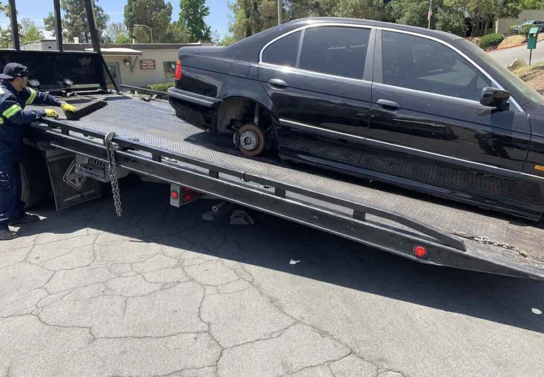 Flatbed tow truck operator loading a vehicle onto the bed in Bay Shore, NY