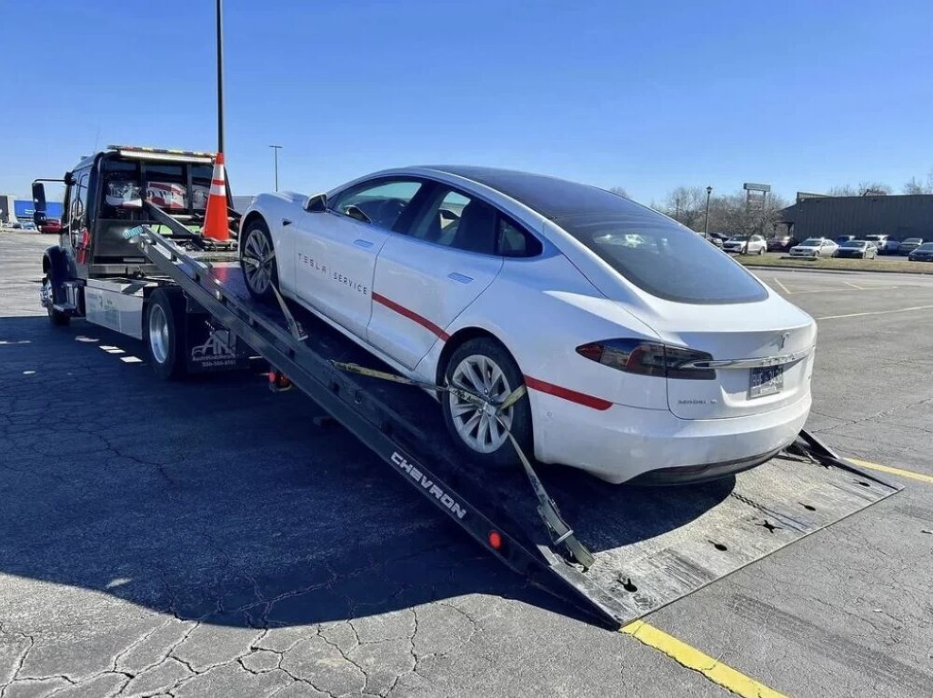White Tesla Model S being loaded onto a flatbed for long distance towing in Bay Shore, NY